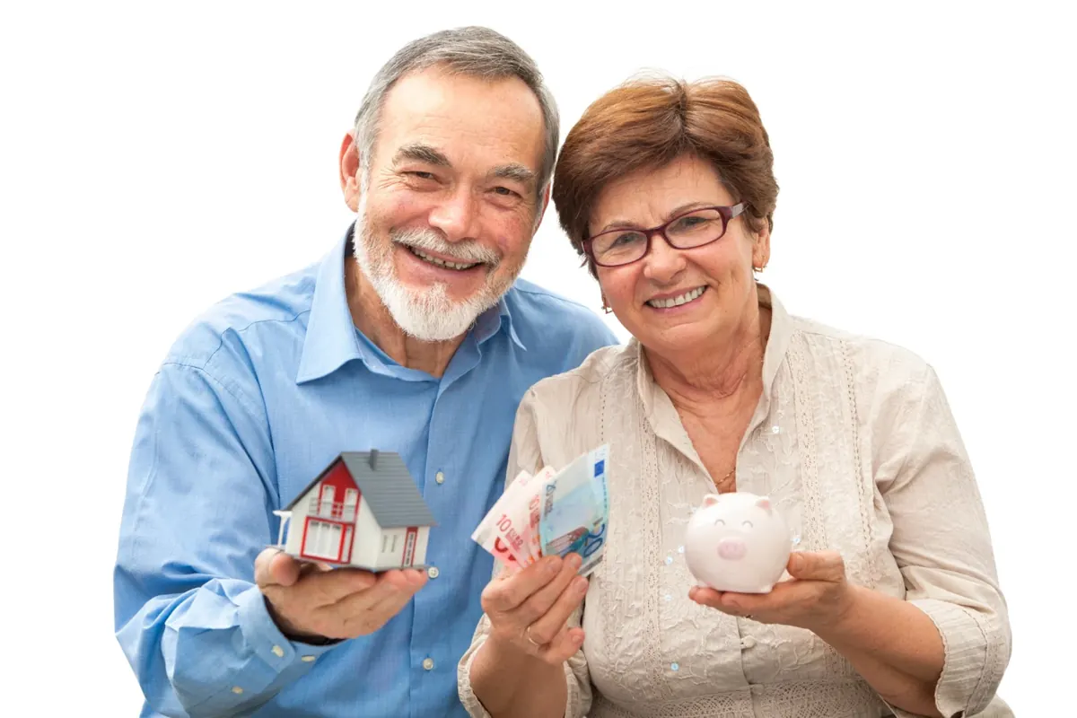Senior couple holding a model house, savings and a piggy bank