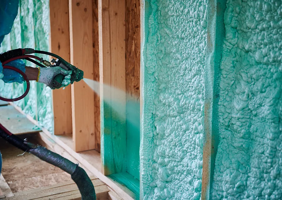 Spray foam insulation being installed between wall studs