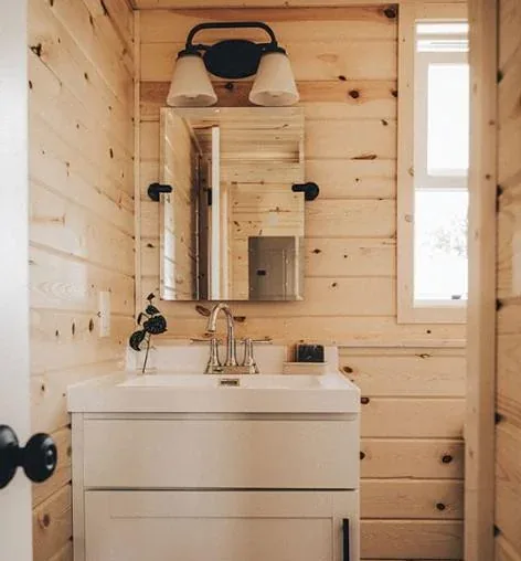 A vanity and mirror in a tiny home bathroom