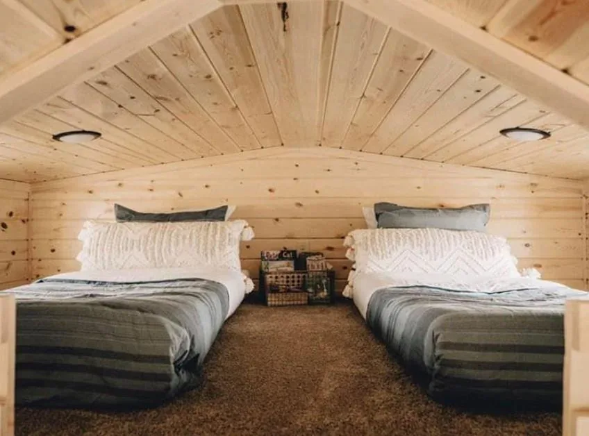 A cozy tiny home bedroom with a full bed