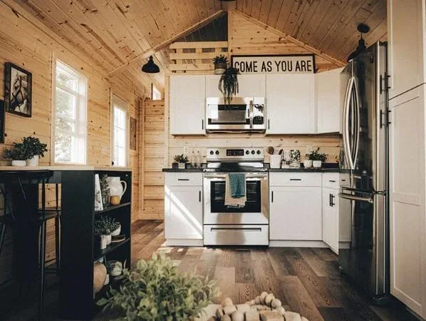 A tiny home kitchen with full-size appliances and wood finishes