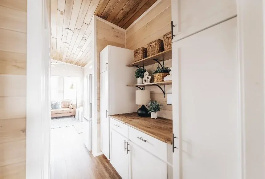 White cabinetry and open shelving in a tiny home kitchen