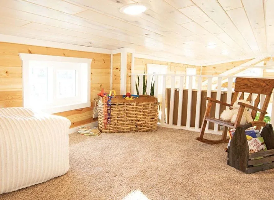 An open loft space with railing in a tiny home
