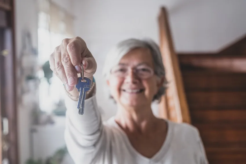 A homeowner holding the keys to her new tiny home